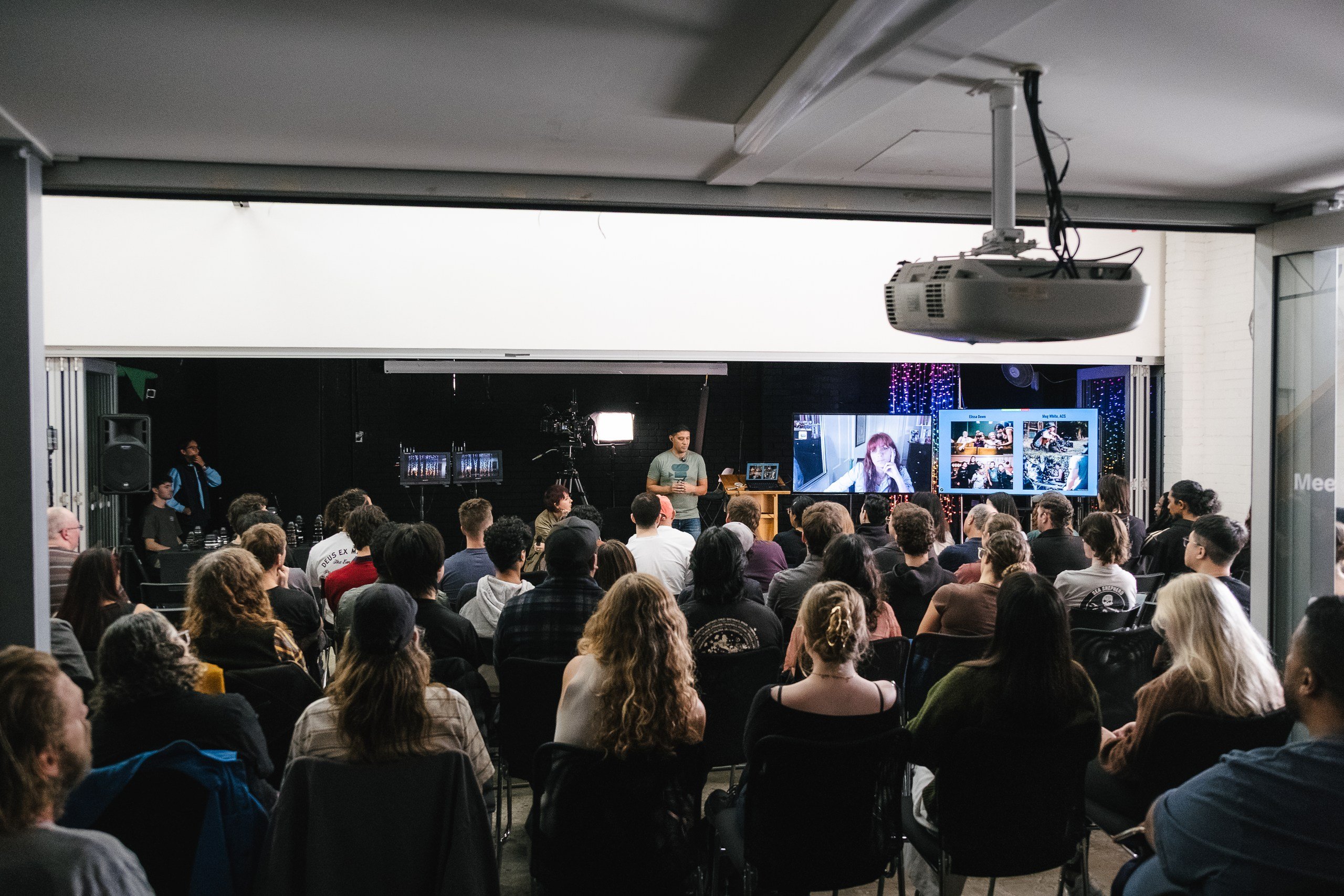 Audience watching workshop presenter with two screens